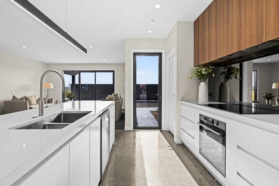 Kitchen with a white stone island and timber joinery in a Palmer Builders home