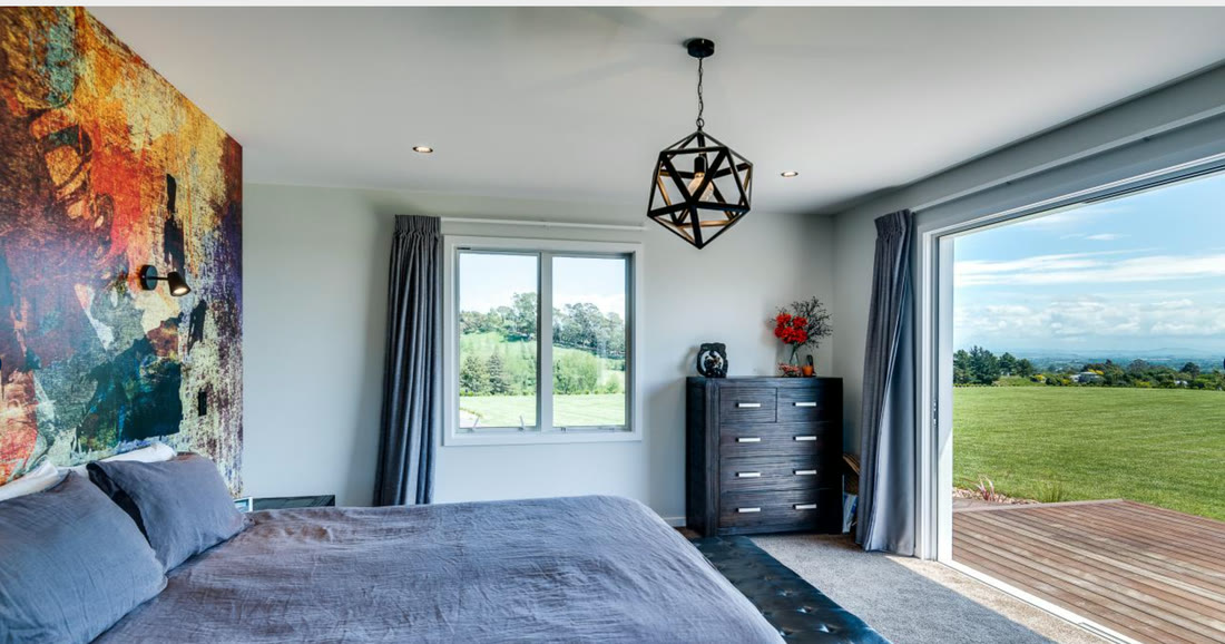 Bedroom with large windows framing rural views
