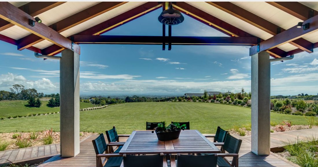 Covered outdoor dining area with timber ceiling and rural views