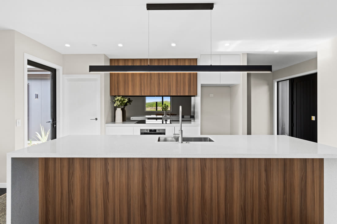 Kitchen with dark cabinetry, stone benchtops and rural views