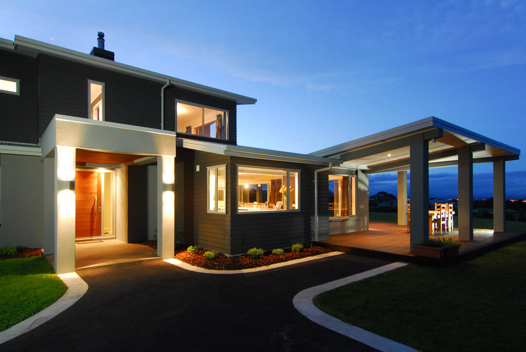 Modern dark-clad home exterior with landscaped grounds