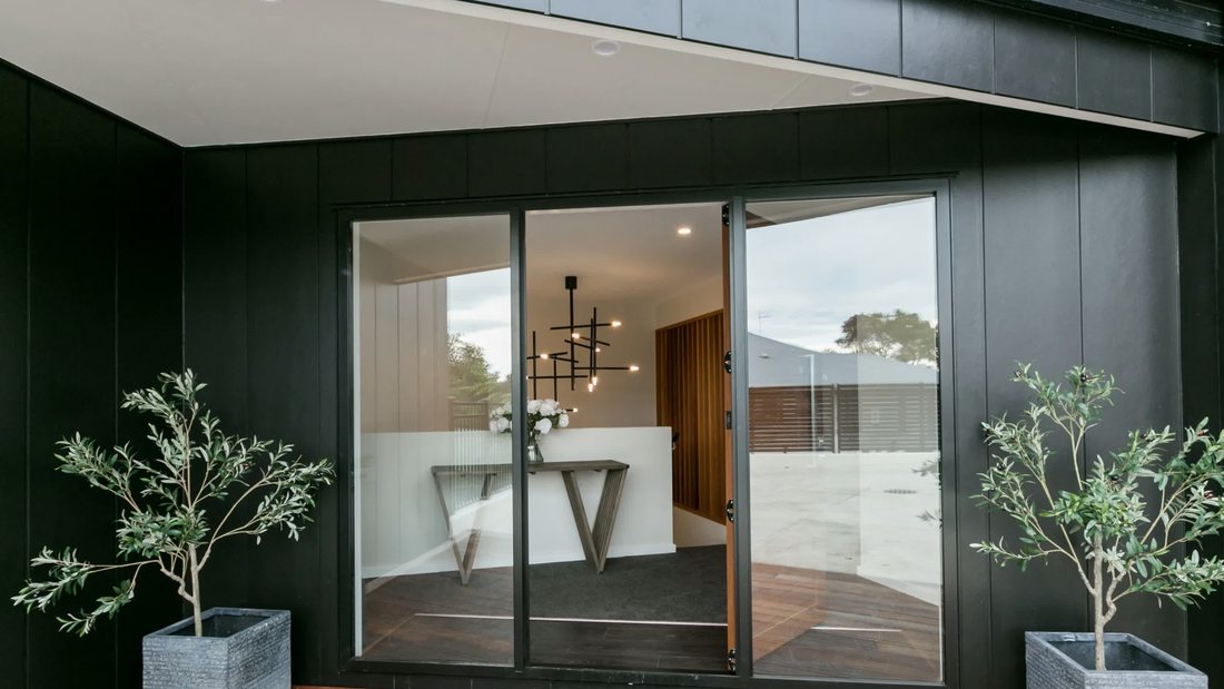 Dark-clad exterior with stacking sliding doors to the interior